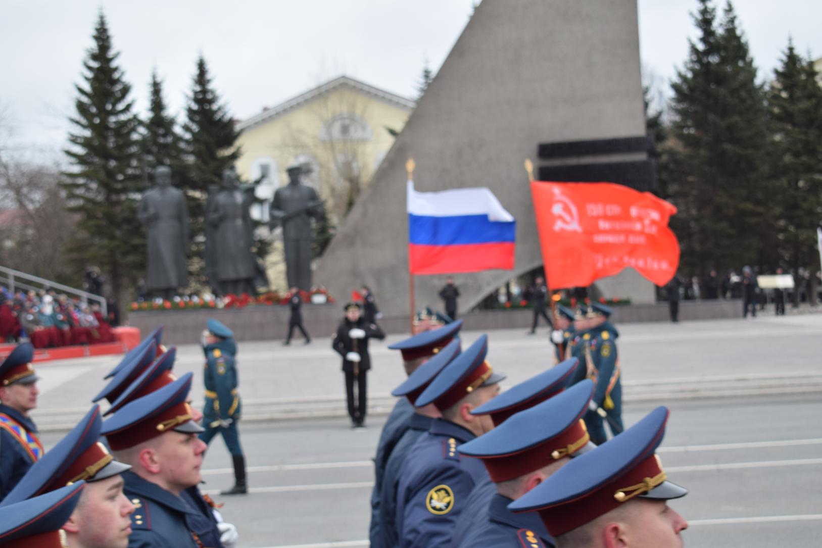 Во главе парада - государственный флаг и знамя Победы